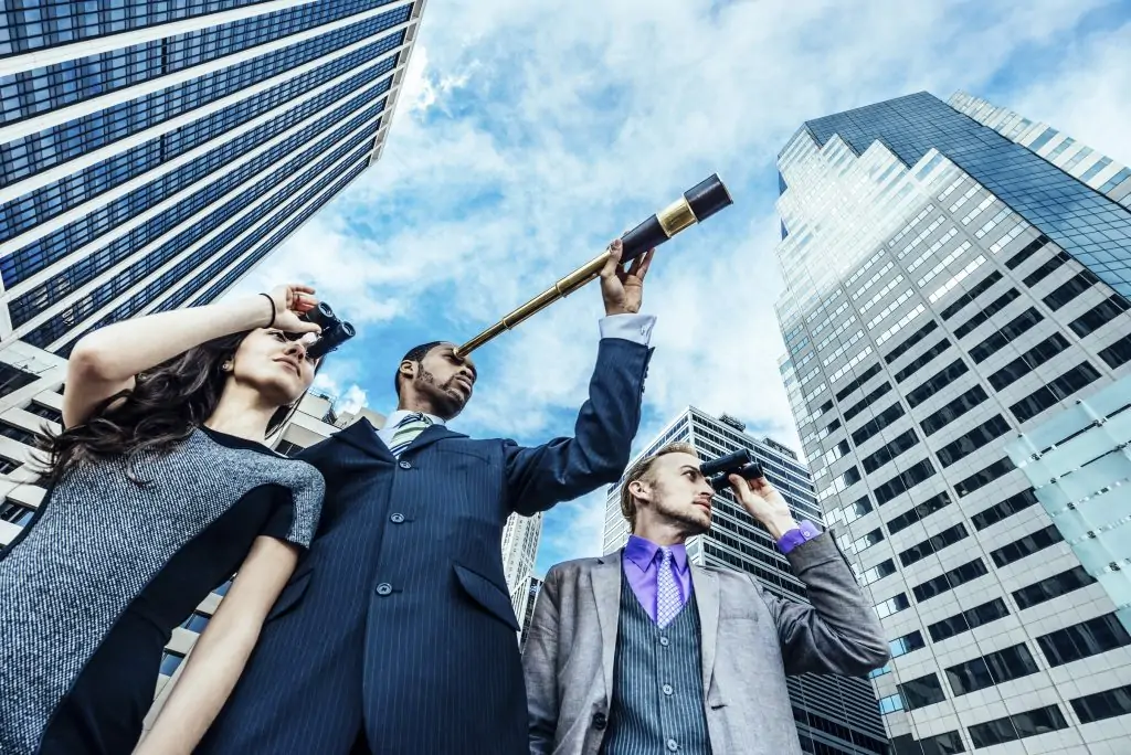 Three people in a city searching with spy glasses