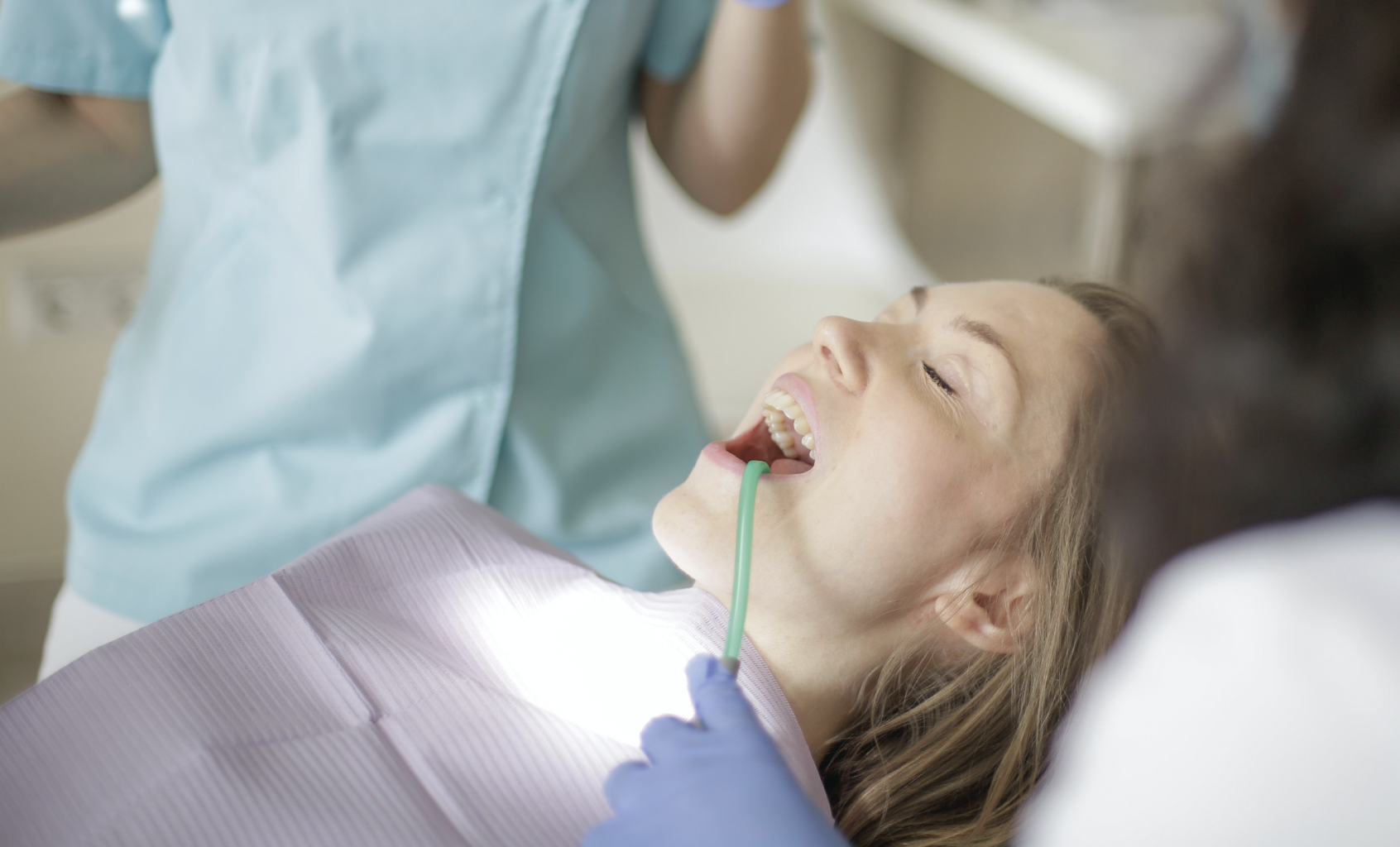 woman under IV sedation getting her teeth inspected