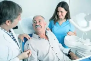 elderly man smiling in a dentist chair
