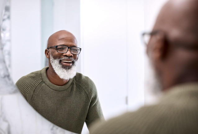 older man smiling in the mirror