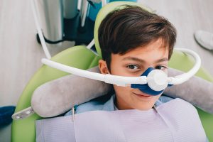Young boy with a nose mask for sedation before a dental procedure.