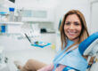 Happy woman visiting a dentist office in dental chair