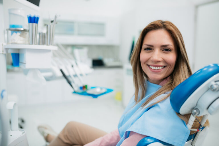 Happy woman visiting a dentist office in dental chair
