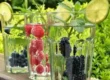 drinking glasses filled with water and fruit with a lime on top