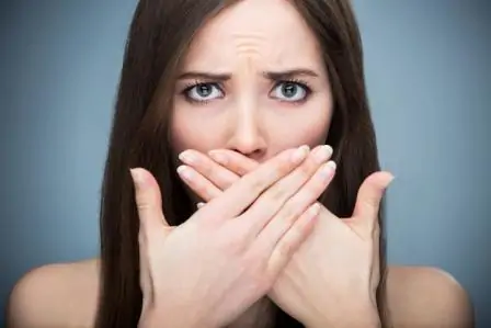 Woman covering her mouth.