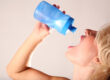 Female desperately drinks water out of a water bottle